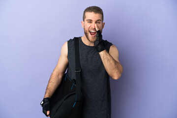 Young sport man with sport bag isolated on white background shouting with mouth wide open