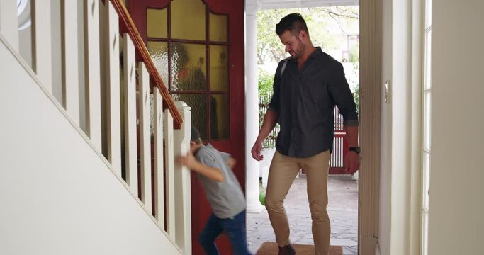 Finally home from a busy day. Little boy coming back home with his dad and tacking off his jacket before running upstairs. Father cleaning up after son after returning home