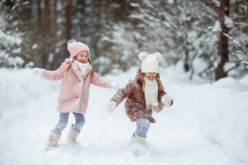 children run and play in the winter forest