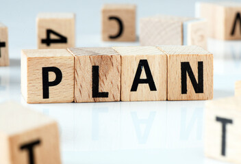 PLAN word arranged with wooden letters on a white background.