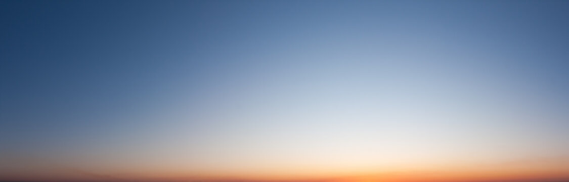 Clear blue sky in evening with bright sunset panorama