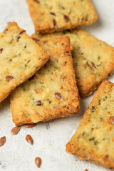 Homemade diet cookies with herbs, flaxseed and spices on light table. Macro photo low depth of field of herbal crunchy crackers or vegetable loaves