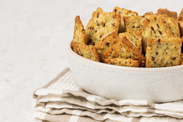 Homemade diet cookies with herbs, flaxseed and spices in a light plate on a light table. Herbal...