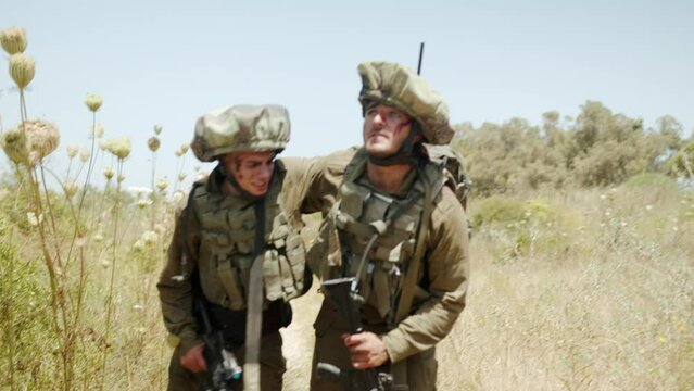 Two injured soldiers walking side by side talking each other through the horrible situation they are in. Close up shot