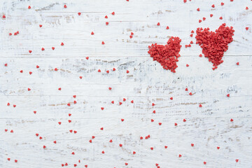 Happy St. Valentine Day greetings card. Big and small red hearts on white wooden background 