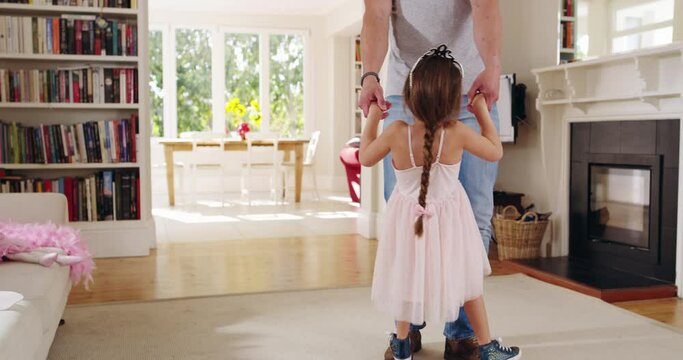 Im proud of you my little girl. Handsome young Dad dancing with daughter at home in the lounge. Adorable little girl standing on father's toes and dancing, bonding, kissing hand, trust, single dad