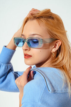 Close up fashion portrait of elegant woman wearing trendy blue sunglasses