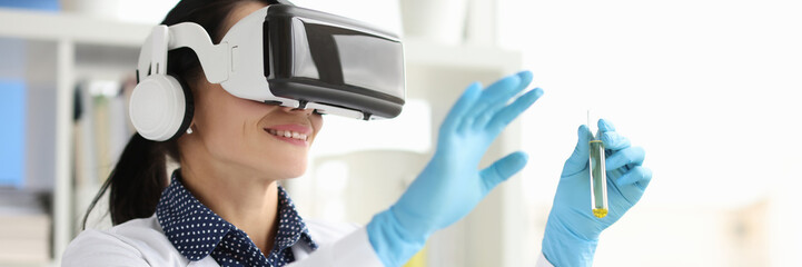 Woman scientist chemist in virtual reality glasses holding test tube in laboratory