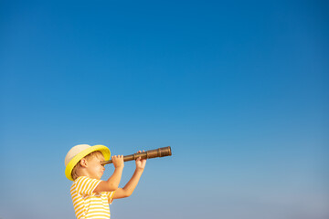 Child looking through spyglass in summer