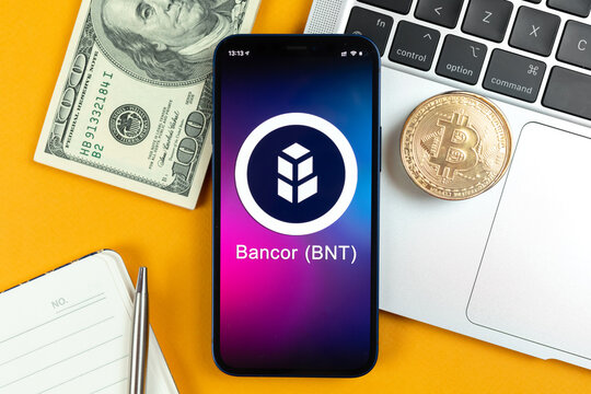 Bankor BNT coin symbol. Trade with cryptocurrency, digital and virtual money, banking with mobile phone concept. Business workspace, table with laptop top view photo