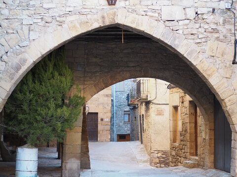 arco ojival dovelado en piedra en el pueblo  medieval de guimera, al fondo arco de medio punto, lerida, españa, europa