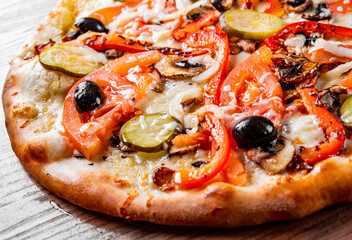 vegetarian pizza with Mozzarella cheese, grilled zucchini, mushrooms, red onion, pepper and olive. Italian pizza on wooden table background