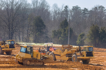 large wheel loader aligns a piece of land for a new building