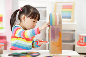 young girl making bird hourse craft for home schooling