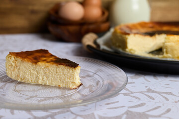 Creamy cheesecake with eggs and milk on brown and white background