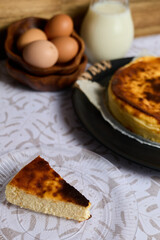 Creamy cheesecake with eggs and milk on white background