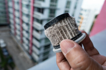 Household handheld vacuum cleaner filter clogging up with dust, mite, hair, and animal fur after an...