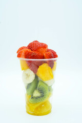 Vaso de platico con varios trozos de fruta cortada