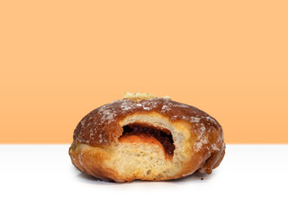 Bitten donut with fruit jam on a fat thursday on an isolated background.