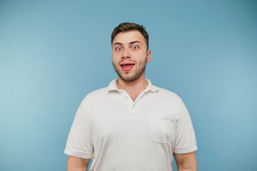 Fototapeta premium Funny stupid man with bristles isolated on blue background, looks at the camera and laughs.