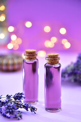Lavender oil and lavender flowers on bokeh background