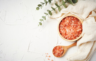 top view Himalayan salt raw crystals in wood spoon and bowl on white table background with copy...