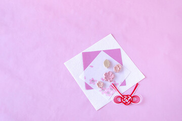 桜模様の和紙の上の桜の干菓子と紅白の水引