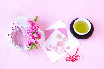 桜模様の和紙の上の桜の干菓子と桜のリースと紅白の水引