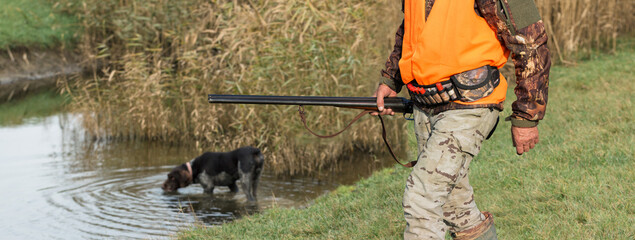 Hunter man in camouflage with a gun during the hunt in search of wild birds or game. Autumn hunting...