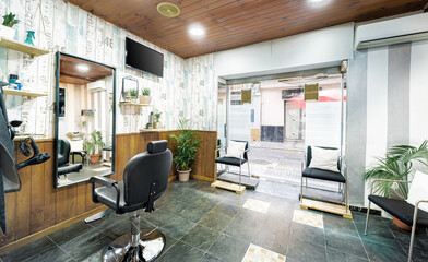 Vintage beauty salon. Hair salon interior business with retro organic minimal look. Wooden decoration with wood panels, raw wall with bricks, mirrors, chairs,tv screen and mockup banners