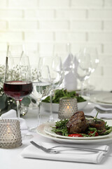 Delicious grilled meat with vegetables and wine served on table in restaurant