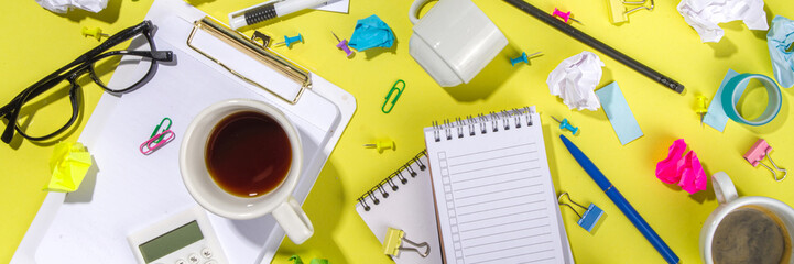 Brainstorming office table background. Office work table with notepads, pens, pencils, crumpled colorful paper, office supplies. Creative business team brainstorming concept flatlay yellow background 