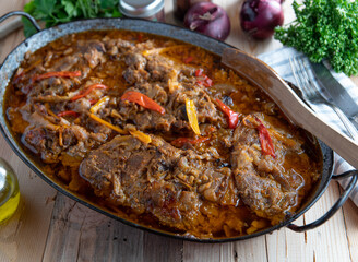 Meat with vegetables in a roasting pan. Spicy pork neck cooked with onions, garlic, bell peppers in a roasting pan