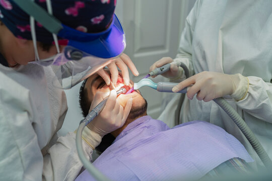 team of dentists removing a tooth from a patient