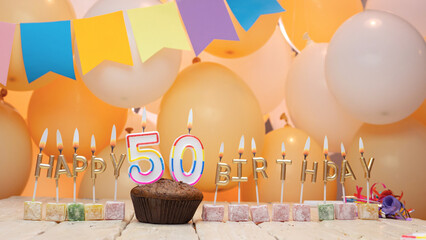 Happy birthday greetings for 50 years from gold letters of candles burning against the background...