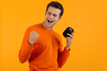 stylish young man holding wireless speaker