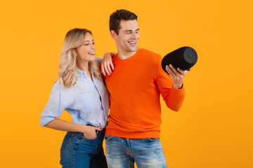 attractive stylish young couple holding wireless speaker