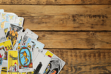 Fototapeta na wymiar Tarot cards on wooden table, top view. Space for text