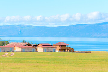 Fototapeta na wymiar Cute houses at sunny summer day with a view of lake Baikal. Beauty of nature concept