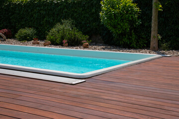 Fototapeta na wymiar Swimming pool with teakwood flooring stripes summertime leisure ideas