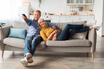 Relaxed Senior Couple Watching Television Sitting On Sofa At Home