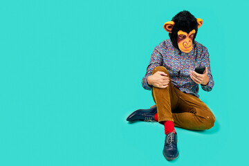 man with a monkey mask is using his smartphone