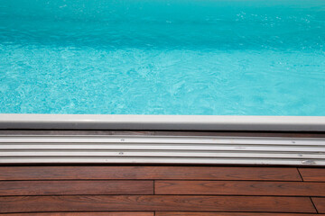 Fototapeta na wymiar Horizontal lines of wood and edging pool enclosure aluminum tracks in detail