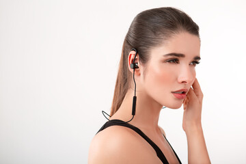 attractive woman in jogging black top listening to music on earphones