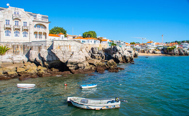 Panoramic view of sandy bay from city - Cascais, portuguese coast at Atlantic. Fishing boat with fishing net and equipment  