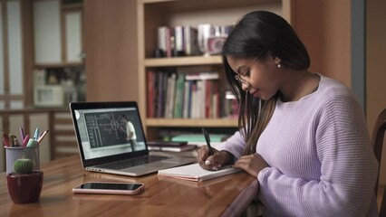 Young Female black Student Watching online lesson with math teacher. Girl Studying and taking notes from home Online Education and e-learning