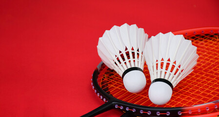 Cream white badminton shuttlecock and racket on floor in indoor badminton court, copy space, soft and selective focus on shuttlecocks.