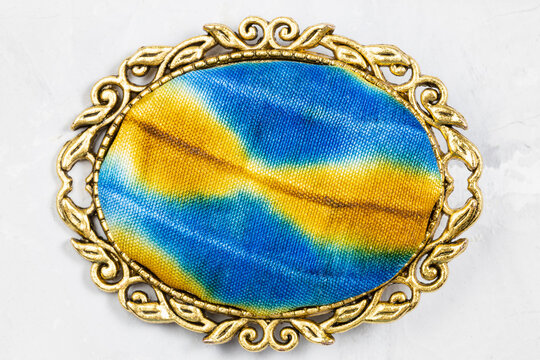brass brooch with hand-colored silk batik on gray