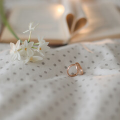 Wedding golden ring and open book with folded sheets in heart shape in bed. Wedding concept, Happy Valentine's Day