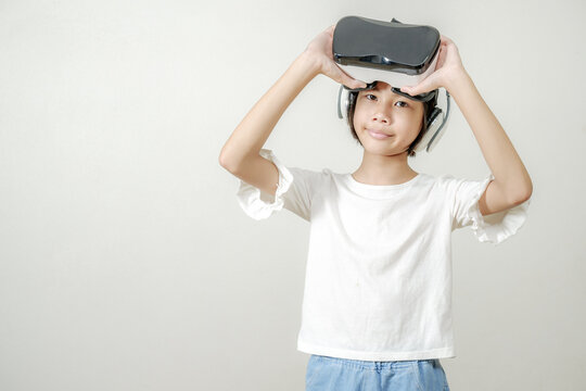 Smiling girl with glasses of virtual reality,VR application test Asian child girl with virtual reality glasses headset touching air during the VR experience, 